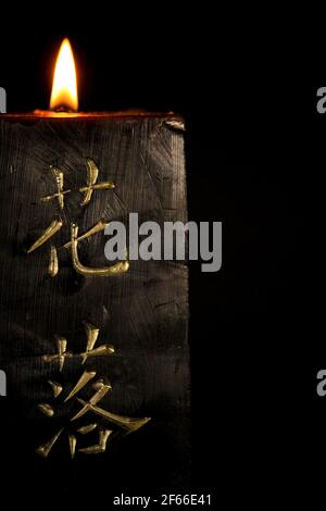 Candela nera con lettere giapponesi che bruciano su sfondo nero Foto stock  - Alamy