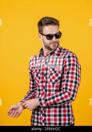 giovane bell'uomo in camicia a scacchi e occhiali da sole ha setole sul viso, stile casual Foto Stock