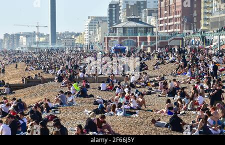 Brighton UK 30 marzo 2021 - Brighton Beach è piena di visitatori che affollano il mare il giorno più caldo dell'anno, con temperature che raggiungono la metà degli anni '20 centigradi in alcune parti del Sud Est: Credit Simon Dack / Alamy Live News Foto Stock