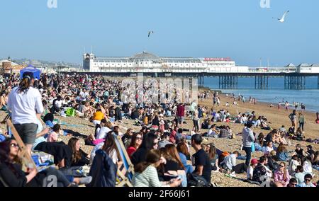 Brighton UK 30 marzo 2021 - Brighton Beach è piena di visitatori che affollano il mare il giorno più caldo dell'anno, con temperature che raggiungono la metà degli anni '20 centigradi in alcune parti del Sud Est: Credit Simon Dack / Alamy Live News Foto Stock