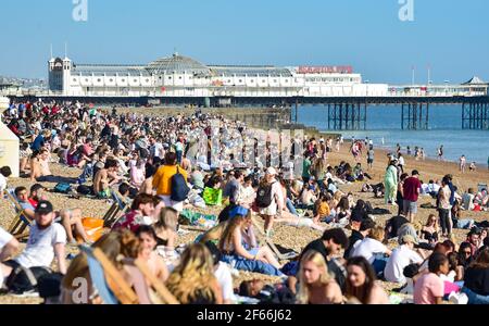 Brighton UK 30 marzo 2021 - Brighton Beach è piena di visitatori che affollano il mare il giorno più caldo dell'anno, con temperature che raggiungono la metà degli anni '20 centigradi in alcune parti del Sud Est: Credit Simon Dack / Alamy Live News Foto Stock