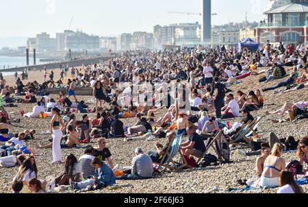 Brighton UK 30 marzo 2021 - Brighton Beach è piena di visitatori che affollano il mare il giorno più caldo dell'anno, con temperature che raggiungono la metà degli anni '20 centigradi in alcune parti del Sud Est: Credit Simon Dack / Alamy Live News Foto Stock