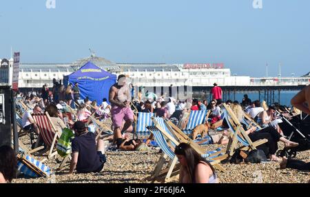 Brighton UK 30 marzo 2021 - Brighton Beach è piena di visitatori che affollano il mare il giorno più caldo dell'anno, con temperature che raggiungono la metà degli anni '20 centigradi in alcune parti del Sud Est: Credit Simon Dack / Alamy Live News Foto Stock