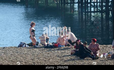 Brighton UK 30 marzo 2021 - Brighton Beach è piena di visitatori che affollano il mare il giorno più caldo dell'anno, con temperature che raggiungono la metà degli anni '20 centigradi in alcune parti del Sud Est: Credit Simon Dack / Alamy Live News Foto Stock