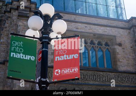 Ottawa, Ontario, Canada - 20 marzo 2021: Le bandiere "Get into Nature" appendono all'esterno del Canadian Museum of Nature. Foto Stock