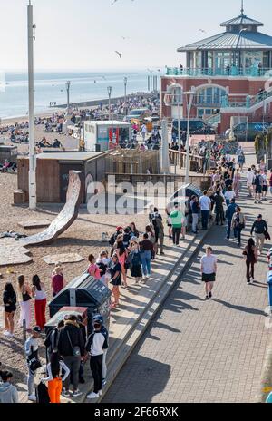 Brighton UK 30 marzo 2021 - la coda dei servizi igienici pubblici si estende lungo il lungomare di Brighton, mentre i visitatori si affollano sul mare il giorno più caldo dell'anno, con temperature che raggiungono la metà degli anni '20 centigradi in alcune parti del Sud-Est : Credit Simon Dack / Alamy Live News Foto Stock