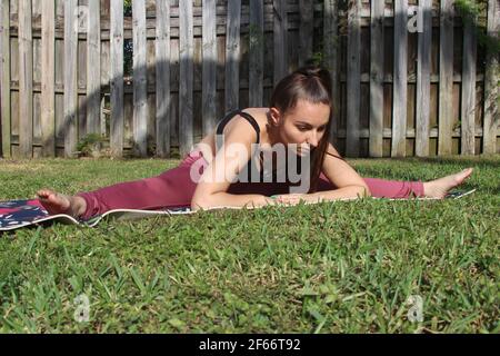 Giovane donna fare yoga al di fuori Foto Stock