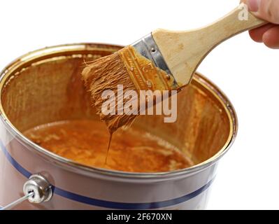 secchio di vernice con smalto di legno marrone e pennello usato, primo piano Foto Stock