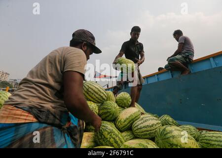 Dhaka, Bangladesh. 30 Marzo 2021. I lavoratori del Bangladesh scaricano il melone dalle imbarcazioni di Sadarghat a Dhaka, Bangladesh, il 30 marzo 2021. Credit: Suvra Kanti Das/ZUMA Wire/Alamy Live News Foto Stock
