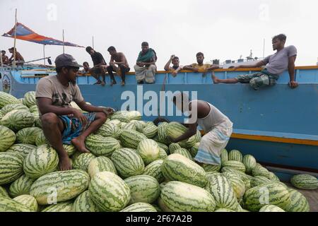 Dhaka, Bangladesh. 30 Marzo 2021. I lavoratori del Bangladesh scaricano il melone dalle imbarcazioni di Sadarghat a Dhaka, Bangladesh, il 30 marzo 2021. Credit: Suvra Kanti Das/ZUMA Wire/Alamy Live News Foto Stock