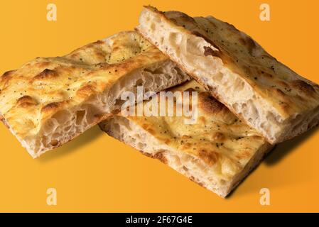 Focaccia genovese al forno - pane di pasta - fette tagliate mostrando gli alveoli come test di resistenza del glutine - isolato su sfondo giallo Foto Stock