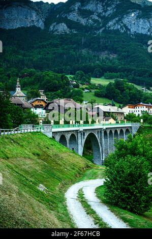 Alto e lungo ponte in pietra con archi multipli in Mieussy. Alte pareti di pietra ripide sullo sfondo. Bellezza della regione dei monti Giffre, Francia. Foto Stock