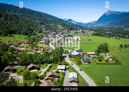 Drone vista di case sparse in prati verdi nella valle di montagna. Bellezza della regione dei monti Giffre, Francia. Foto Stock