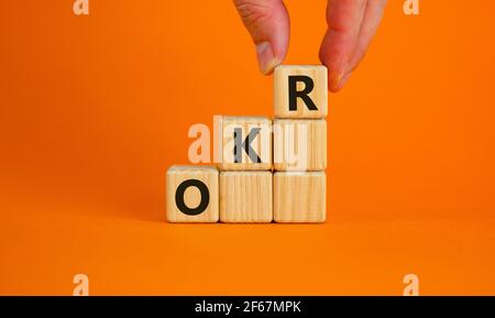 Simbolo OKR, obiettivi e risultati chiave. Parole chiave "OKR, obiettivi e risultati chiave" sui cubi su uno splendido sfondo arancione. Business, OKR - obj Foto Stock