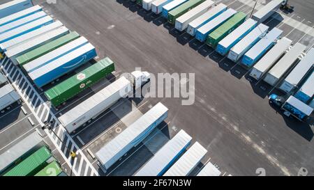 vista angolare dei veicoli industriali e dei loro rimorchi in attesa Foto Stock