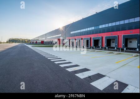 Ampia vista mattutina di lunghe file di vani di carico vuoti in una nuova area logistica. Trasporti e logistica, edilizia industriale moderna e tecnologia. Foto Stock