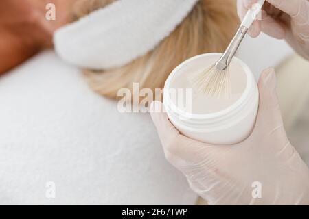 Primo piano di mani di cosmetologist che tengono il vaso di maschera. Concetto di bellezza e cura del corpo Foto Stock