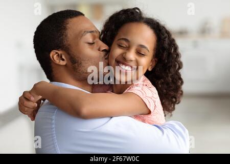 Amato papà nero baciare la sua bella piccola figlia Foto Stock