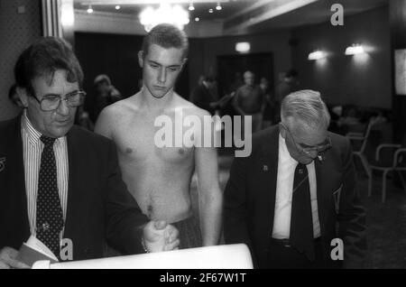 I ragazzi vengono pesati dai funzionari prima della partita di boxe Foto Stock