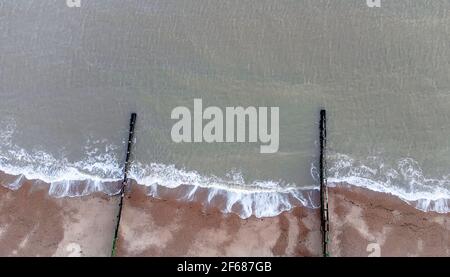 Guardando giù sulle onde che si infrangono su una spiaggia di ghiaia a Suffolk, Regno Unito Foto Stock