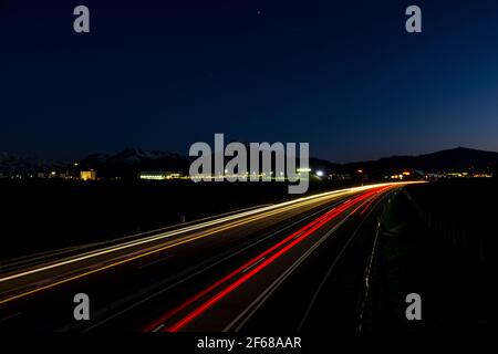 Foto a lunga esposizione di un'autostrada con percorso luminoso del veicolo, girato vicino a Bulle, Friburgo, Svizzera Foto Stock