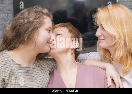 Una giovane ragazza si congratula con sua madre per la vacanza. Abbracci dolcemente e sorride. Foto Stock