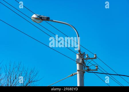 Lampada con fili su sfondo blu, illuminazione urbana Foto Stock