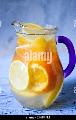 Arance e limoni in una caraffa con acqua Foto Stock