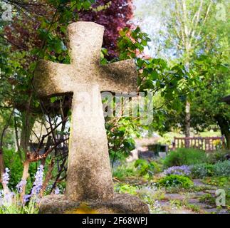 Immagine ravvicinata di una semplice croce in pietra in un cimitero Foto Stock