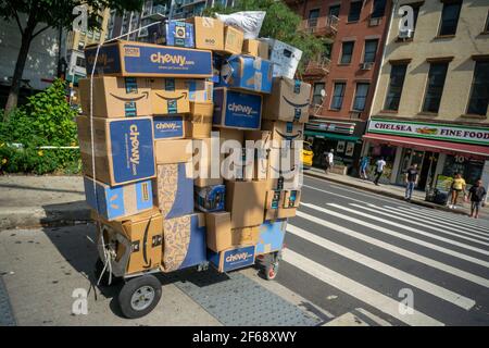 New York, Stati Uniti. 19 Settembre 2018. Un deliveryman da Lasership con il suo carrello carico con gli acquisti da quali Walmart, Chewy, Amazon, ed altri trinces attraverso il quartiere di Chelsea di New York sui suoi giri designati, il mercoledì, 19 settembre 2018. Chewy ha riportato vendite del quarto trimestre che hanno battuto analystsÕ aspettative citando abbonamenti guidati da COVID-19. (Foto di Richard B. Levine) Credit: Sipa USA/Alamy Live News Foto Stock