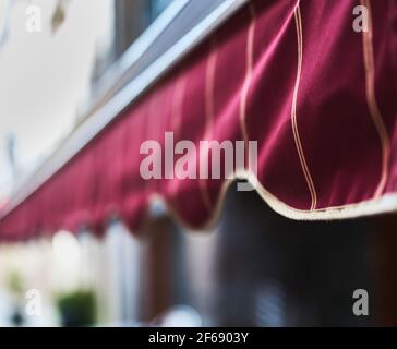 dettaglio di una tenda rossa con strisce dorate in una ristorante o pasticceria Foto Stock