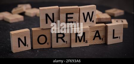 Le parole New Normal scritte su cubi di lettere di legno Foto Stock