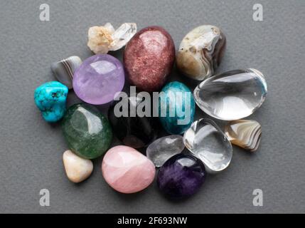 Gemme tumbled di vari colori. Ametista, quarzo rosa, agato, apatite, aventurina, olivina, turchese, acquamarina, cristallo di roccia. Foto Stock