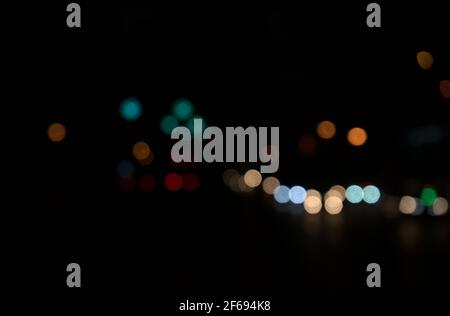 Bokeh di riprese notturne, strada, luci di strada, trasporto astratto in città. Splendide luci colorate sfocate. Geometria circolare casuale. Foto Stock