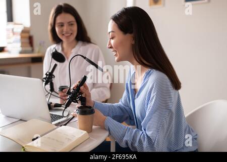 Allegra donna asiatica che parla durante il podcast con un amico Foto Stock