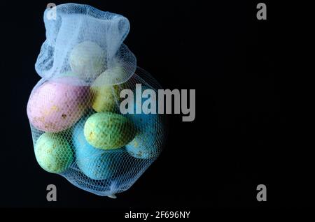 uova di pasqua colorate in una griglia su sfondo scuro, spazio libero Foto Stock