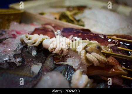 Spiedino di polpo grezzo in una bancarella di mercato a Phuket, Thailandia. Foto Stock