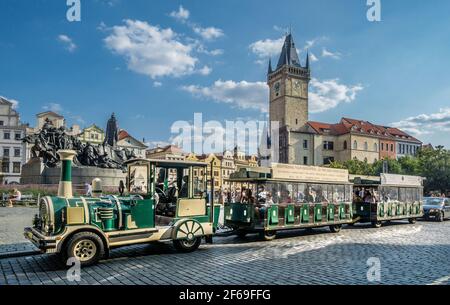 Treno turistico nella Piazza della Città Vecchia di Praga sullo sfondo della torre in pietra del Municipio Vecchio, capitale di Praga, Repubblica Ceca Foto Stock