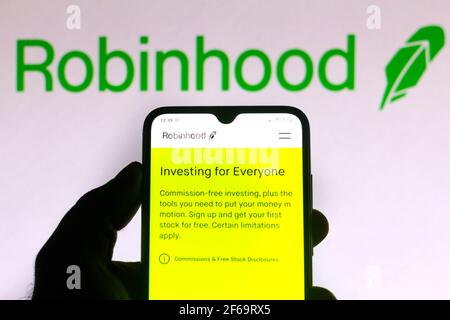 In questa illustrazione fotografica il logo Robinhood Markets viene visualizzato sullo schermo di uno smartphone e di un pc. Foto Stock