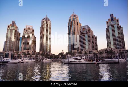 Vista dei bellissimi scrappers cielo, appartamenti, ponte delle navi da crociera e gli hotel catturati durante la sera dal Marina Mall, Dubai, Emirati Arabi Uniti. Foto Stock