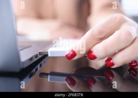 Mano femmina che inserisce il flash usb nel closeup del laptop Foto Stock
