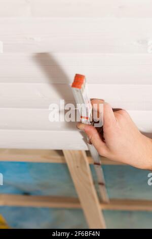 Uomo che fa walling a secco, lavorando con una regola di piegatura Foto Stock