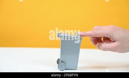 cestino grigio su sfondo giallo Foto Stock