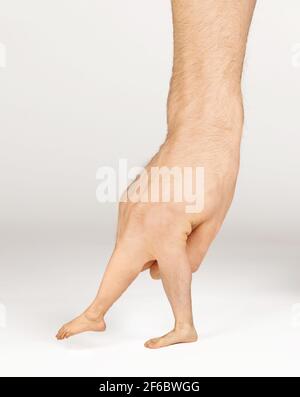 Mano spaventosa con gambe e piedi invece di dita, isolata su bianco Foto Stock