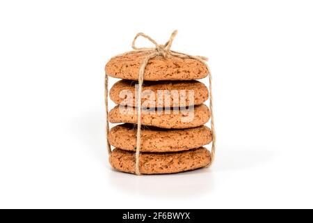 Biscotti fatti in casa. Cinque biscotti dolci fatti con farina d'avena, accatastati e legati con corda di lino in stile rustico. Gustoso biscotto in alta risoluzione vicino Foto Stock
