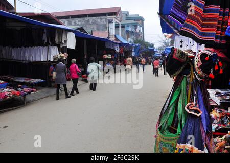 SAPA, VIETNAM - 22 FEBBRAIO 2013: Turisti a piedi nel mercato di Bac ha nel Vietnam del Nord. Bac ha è mercato della tribù delle colline dove la gente viene a commerciare per il g Foto Stock