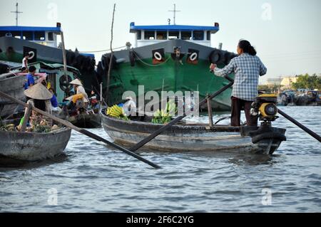 CAI RANG, VIETNAM - 17 FEBBRAIO 2013: Persone che viaggiano e lavorano con le loro barche di legno nel delta del Mekong dove il trasporto è possibile solo su b Foto Stock