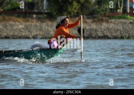 CAI RANG, VIETNAM - 17 FEBBRAIO 2013: Persone che viaggiano e lavorano con le loro barche di legno nel delta del Mekong dove il trasporto è possibile solo su b Foto Stock