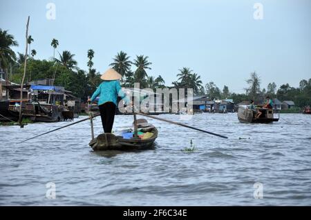 CAI RANG, VIETNAM - 17 FEBBRAIO 2013: Persone che viaggiano e lavorano con le loro barche di legno nel delta del Mekong dove il trasporto è possibile solo su b Foto Stock