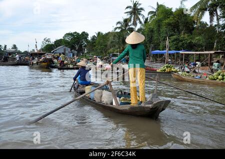 CAI RANG, VIETNAM - 17 FEBBRAIO 2013: Persone che viaggiano e lavorano con le loro barche di legno nel delta del Mekong dove il trasporto è possibile solo su b Foto Stock